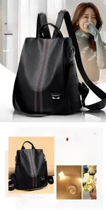 Detailed view of black litchi texture backpack with striped ribbon and monster eye patch