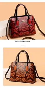 Macro-opname van de Chinese bloemenreliëf en het gouden kangoeroe-logo op de tas