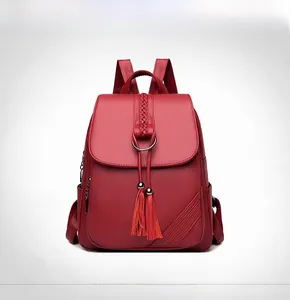 Front angle display of dark red leather backpack with tassels and pebble texture detail