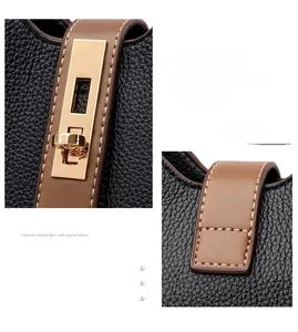 Detail of contrast stitching and gold metal buckle on textured cowhide bucket bag