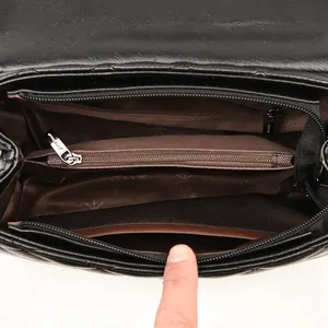 Internal view of black quilted leather shoulder bag with multiple compartments and star print