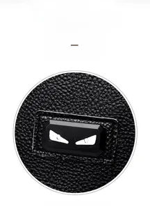 Detail of lychee pattern leather backpack with metallic monster eye decoration