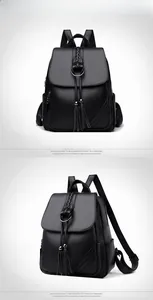 Detail view of black textured leather backpack with metal ring and braided tassel