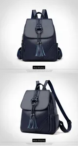 Detail of blue textured leather backpack featuring tassel charms and woven top handle