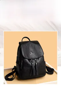 Detailed view of black textured leather backpack featuring fringe zippers and logo