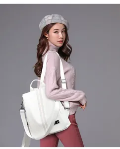 Detailed view of white lychee leather backpack with colored stitching and wide strap
