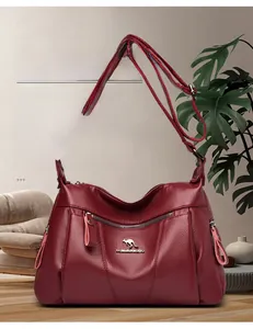 Dettaglio borsa a tracolla in pelle bordeaux a grana litchi con logo a canguro