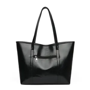 Sac cabas en similicuir noir verni avec longues anses et poche extérieure zippée argentée