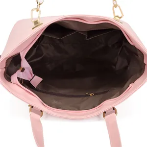 Interno della borsa tote rosa con fodera marrone, finiture dorate e tasche multifunzione