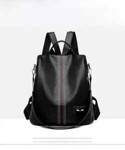 Close-up of black lychee grain leather backpack with stripe detail and eye pattern