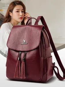 Side view of large burgundy faux leather backpack with metallic tassel and kangaroo logo