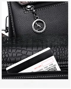 Detail of silver kangaroo logo zipper and rear zip pocket on black embossed tote bag