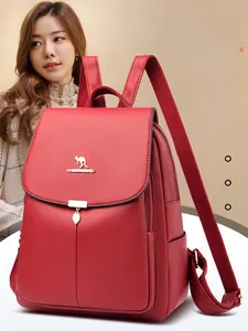 Détail du sac à dos en similicuir rouge avec logo kangourou doré et pendentif feuille