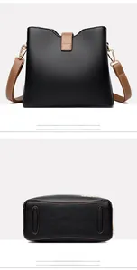 Detail view of black pebble leather bucket bag showing back panel and protective base strips