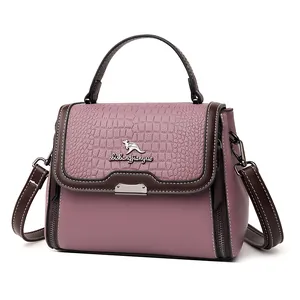 Pink crocodile-embossed satchel with top handle and adjustable shoulder strap
