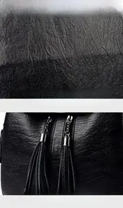 Detail of black pebbled leather texture with metal zipper and long tassel on the backpack