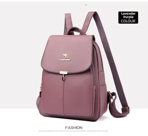Détail du sac à dos en cuir violet avec logo kangourou doré et pendentif feuille chic