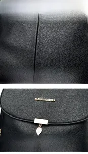 Détail de la texture cuir noir grainé avec logo kangourou doré et pendentif feuille