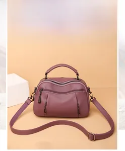 Detail of dusty pink boston bag showing double front zipper pockets and top handles