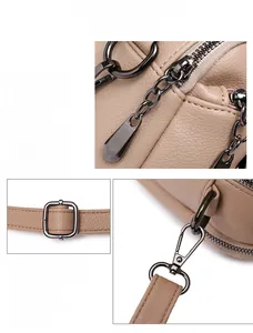 Detailed macro view of beige pebble leather texture with gunmetal hardware and zippers