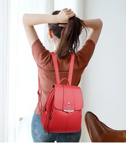 Vista detallada de mochila roja con cierre de flor y correas de cuero ajustables