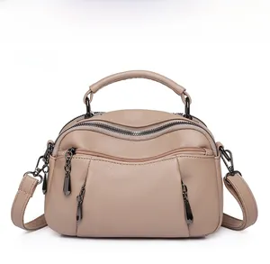 Detailed close-up of khaki Boston bag with dual zippers and pebble grain texture