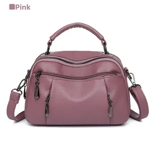 Detail view of pink pebbled leather texture and layered zipper design on a Boston bag