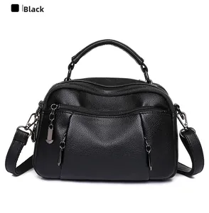 Detail of black pebbled leather Boston bag with dual zippers and gunmetal hardware