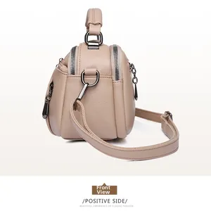 Detail view of beige lychee grain faux leather Boston bag with gunmetal grey zippers
