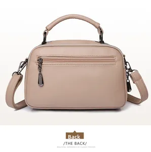 Detailed back view of beige pebbled leather Boston bag with metal zipper pocket