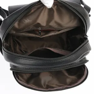 Vista interior de mochila de cuero negro con bolsillos multicapa y compartimentos de cremallera