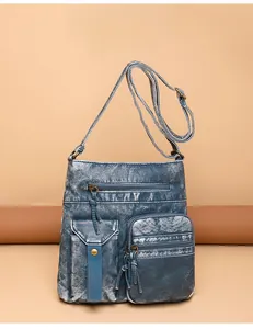 Detail view of blue washed denim style PU leather bucket bag with multiple vintage pockets