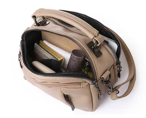 Top view of compact Boston bag with multi-layer interior holding phone and cosmetics