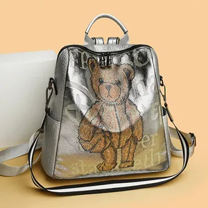 Silver metallic leather backpack featuring a crystal bear design and striped shoulder strap