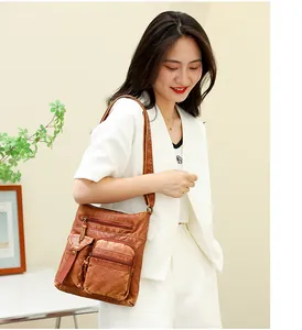 Close-up of vintage brown leather bucket bag with multiple zippers and pockets detail