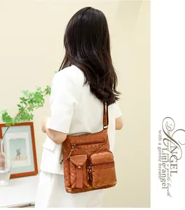 Detail of vintage brown faux leather bucket bag with multiple functional zip pockets