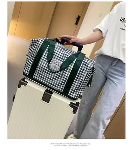 Λεπτομέρεια τσάντας ταξιδιού με μοτίβο houndstooth και πράσινους ιμάντες