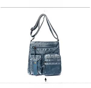 Detail of vintage blue washed leather crossbody bucket bag with functional zip pockets