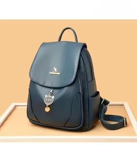 Dettaglio dello zaino in pelle PU blu navy con logo a canguro e ciondolo a gatto