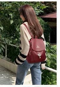 Zaino in pelle rosso scuro con grazioso ciondolo a gatto e logo canguro dorato