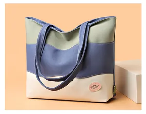 Close-up of canvas bucket bag with green, blue, and cream wave patchwork and strap