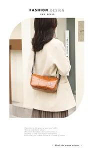 Detail of vintage brown barrel bag featuring quilted stitching and wide patterned strap