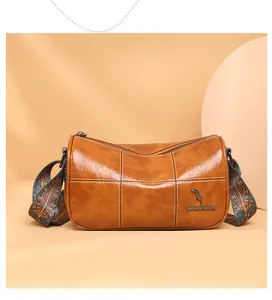 Detailed view of brown cylinder bag showing stitching and ethnic style wide strap