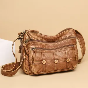 Deep brown washed faux leather crossbody bag with multiple zip pockets and vintage studs