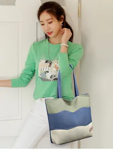Close-up of three-color wave pattern canvas bucket bag with leather Good Luck logo