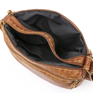 Brown vintage faux leather crossbody bag with triple zipper pockets and bronze hardware
