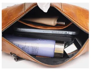 Interior view showing the large capacity and storage compartments of the brown wax leather bag
