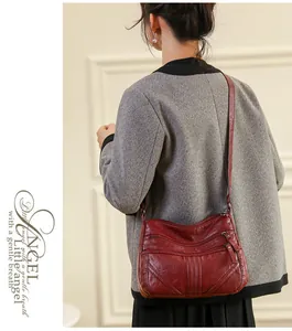 Detail view of burgundy washed leather crossbody bag with multiple zipped compartments