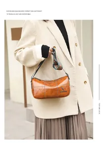 Close-up of caramel leather barrel bag with vintage stitching and geometric woven strap