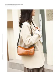 Detail of vintage brown leather cylinder bag with stylish ethnic pattern wide shoulder strap